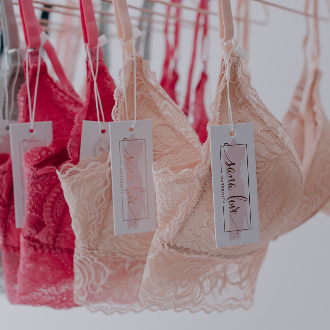 Beige and fuschia lace nursing bras hanging with tag.